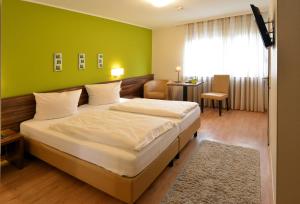 ein Schlafzimmer mit einem großen Bett und einer grünen Wand in der Unterkunft Hotel L' Angolo in Trier