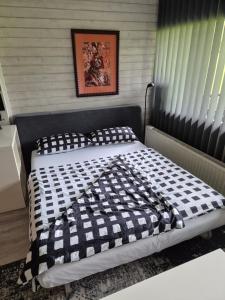 a bedroom with a bed with a black and white comforter at Ferienwohnung mit Pfiff in Siegsdorf