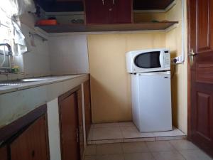 a small kitchen with a microwave on top of a refrigerator at Scenic View Hotel and Resort in Thika