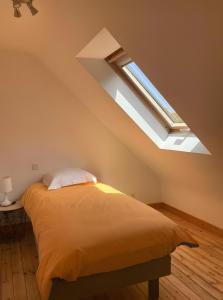 a bedroom with a bed and a skylight at Maison Ty Bastian, 100 M² in Saint-Michel-en-Grève