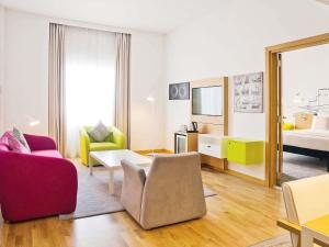 a living room with two chairs and a bed at Mercure Sohar in Sohar