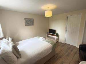 a bedroom with a large white bed and a television at Modern studio flat in Wellington, Telford in Wellington