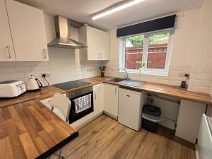 a kitchen with white cabinets and a sink and a table at Modern studio flat in Wellington, Telford in Wellington