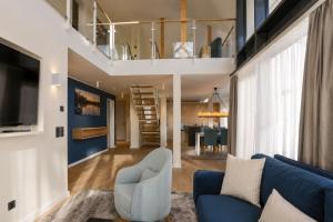 a living room with a blue couch and a loft at Maremüritz Yachthafen Resort in Waren