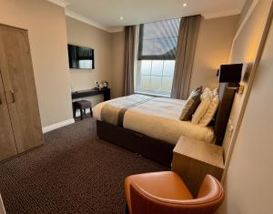 a hotel room with a bed and a desk at The Raven Hotel in Corby +22 photos