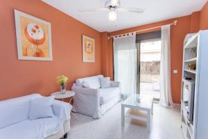 - un salon avec des murs orange et un mobilier blanc dans l'établissement Apartamento Centro Jerez, à Jerez de la Frontera