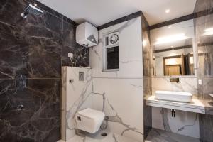 a bathroom with a toilet and a sink and a shower at Hotel Delhi 37 by Star Group in New Delhi +65 photos
