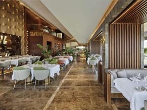 a restaurant with tables and chairs in a room at Mövenpick Hotel Istanbul Bosphorus in Istanbul