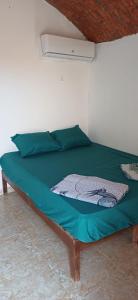 a bed in a room with a green comforter at Viva La Vida Beach Camp in Nuweiba
