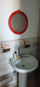 a bathroom with a white sink and a red mirror at Viva La Vida Beach Camp in Nuweiba