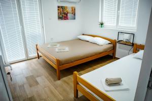 a small room with two beds and windows at Apartmani Grbović in Čanj