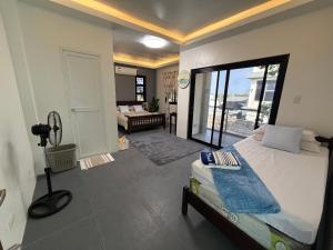 a bedroom with a bed and a view of a balcony at The Coast By RAD in Talisay +23 photos