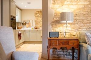 a living room with a couch and a table with a lamp at Beechwood Cottage | Banham Cottages in Bourton on the Water