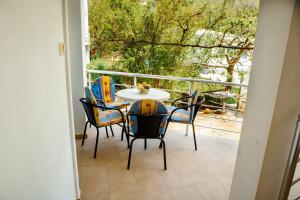 a patio with a table and chairs on a balcony at Apartmani Grbović in Čanj +85 photos