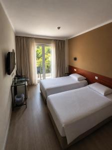 a hotel room with two beds and a television at Hotel London in Athens