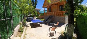 eine Terrasse mit Tisch und Stühlen und ein Haus in der Unterkunft Sabauri in Khulo