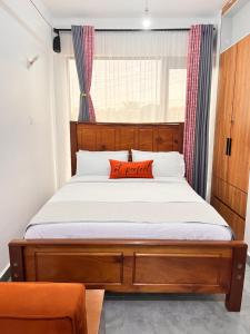 a bed with a wooden headboard in a bedroom at Casa Stays in Kiambu