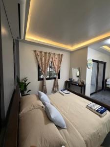 a bedroom with a large bed with a window at The Coast By RAD in Talisay