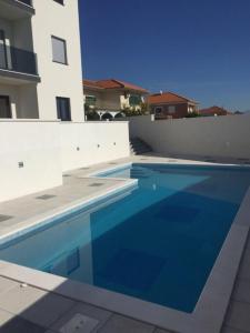 een groot blauw zwembad naast een gebouw bij Luxury in Trogir APARTMANT DRAGO in Trogir