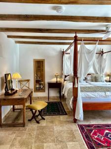 a bedroom with a bed and a table and a desk at Le Moulin sur Célé - Luxury Villas with Private Pool in Saint-Sulpice +76 photos