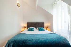 a bedroom with a large bed with blue pillows at Appartement Élégant, Climatisation et Piscine in Ormoy-la-Rivière +17 photos