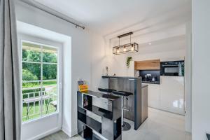 a kitchen with a counter and a window at Appartement Élégant, Climatisation et Piscine in Ormoy-la-Rivière