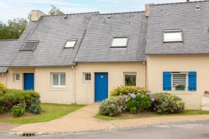 a house with blue doors and flowers at L'Esprit Cap Coz in Fouesnant