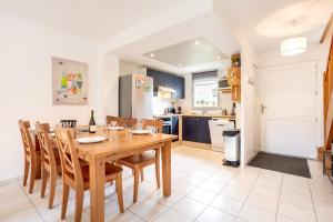 a kitchen and dining room with a wooden table and chairs at L'Esprit Cap Coz in Fouesnant