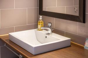 a white bathroom sink with a soap bottle on it at L'Esprit Cap Coz in Fouesnant +17 photos