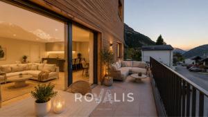 a balcony with couches and a living room with mountains at Panorama Apartment Ried-Brig in Ried-Brig