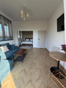 a living room with a blue couch and a table at Apartamenty u Gruzina in Ruda +2 photos