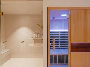 a bathroom with a shower and a glass door at Elysium Noosa Resort - MGallery Collection in Noosa Heads