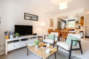 a living room with a television and a table at L'Esprit Cap Coz in Fouesnant