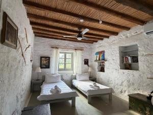 a bedroom with two beds and a window at 3 Bd Stonehouse with Swimming Pool in Paraspóri