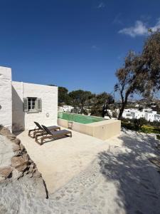 a patio with two benches and a swimming pool at 3 Bd Stonehouse with Swimming Pool in Paraspóri