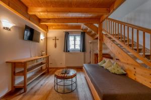 a living room with a couch and a wooden staircase at Zum Kirchenbauer in Oberammergau