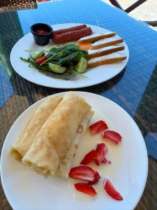 two plates of food on a table with strawberries at Dostar Beach Hotel - Достар Жағажай Қонақүйі in Aktau