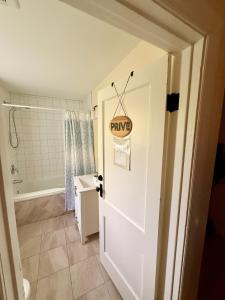 a bathroom with a white door with a sign on it at Gîte de la vallee in Coaticook