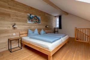a bedroom with a bed with a wooden wall at Zum Kirchenbauer in Oberammergau