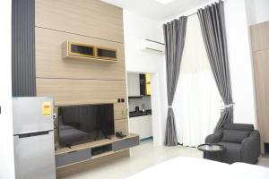 ein Wohnzimmer mit Fernseher, Sofa und Sessel in der Unterkunft White Pole Apartments in Abuja