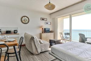 a bedroom with a bed and a dining room with a table at Exceptional stay facing the Atlantic Sea-view apartment with balcony in Saint-Gilles-Croix-de-Vie
