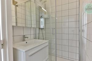 a white bathroom with a sink and a mirror at Exceptional stay facing the Atlantic Sea-view apartment with balcony in Saint-Gilles-Croix-de-Vie
