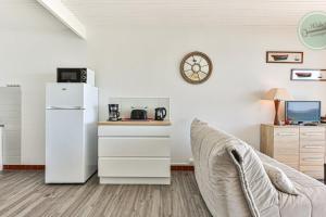 a living room with a white refrigerator and a couch at Exceptional stay facing the Atlantic Sea-view apartment with balcony in Saint-Gilles-Croix-de-Vie +10 photos