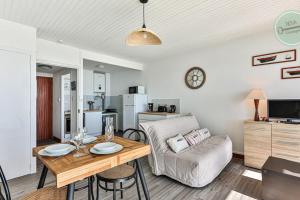 a living room with a table and a couch at Exceptional stay facing the Atlantic Sea-view apartment with balcony in Saint-Gilles-Croix-de-Vie
