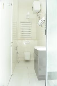 ein weißes Badezimmer mit Toilette und Waschbecken in der Unterkunft White Pole Apartments in Abuja + 24 Fotos