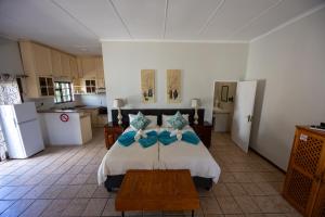 a bedroom with a bed with blue bows on it at Beyond Cui Bono - Travel Addo Group in Sunland
