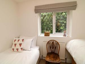 a bedroom with a bed and a chair and a window at The Chimes in Castleton