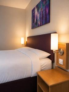 a hotel room with a large bed and a table at Stables Inn, Aintree in Liverpool