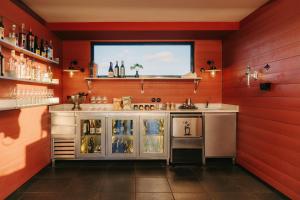 a kitchen with red walls and a counter with a refrigerator at Casa Camper Barcelona in Barcelona +37 photos