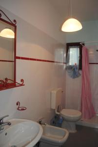a bathroom with a sink and a toilet and a mirror at Appartamenti Spiaggia Bianca in Golfo Aranci
